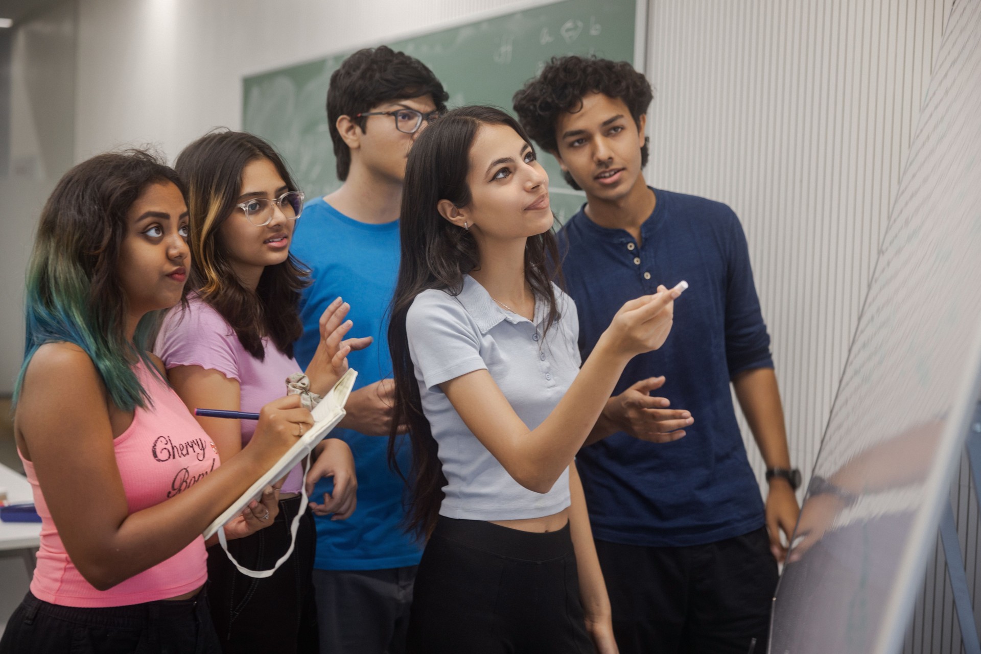 Indian college students on campus studying, using a whiteboard